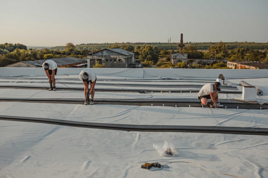 Professional roofers repairing a commercial roof top