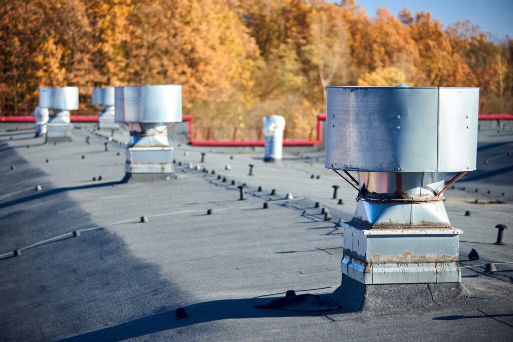 Commercial air ducts on top of a commercial building with a newly installed black roof