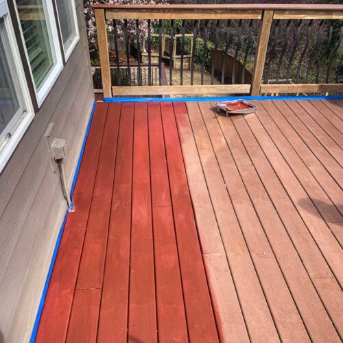 Wooden deck being stained a red color