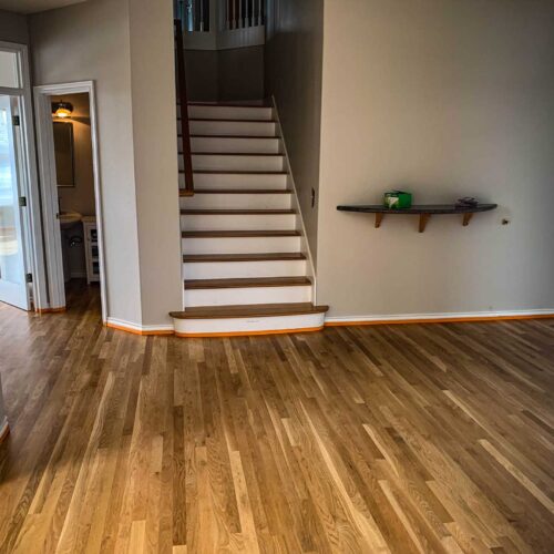 wooden floor in a foyer with a staircase leading to the second story