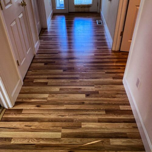 Wood flooring with dark and light panels in a hallway