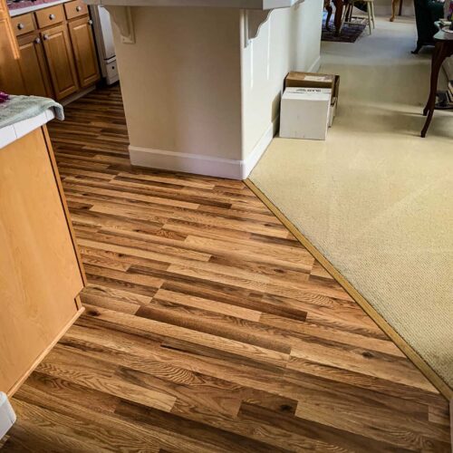 Dark and light wood flooring around a kitchen island