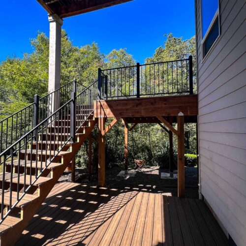 stairway with a metal handrail coming off the second story back deck