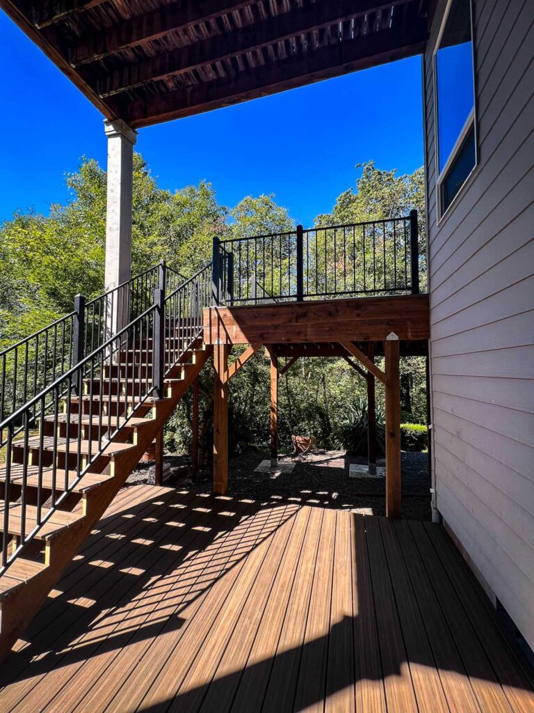 stairway with a metal handrail coming off the second story back deck