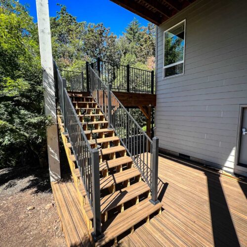 stairway with a metal handrail coming off the second story back deck