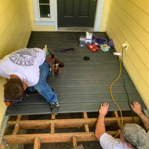 American Mastercraft workers laying wood panels for a new front entrance deck