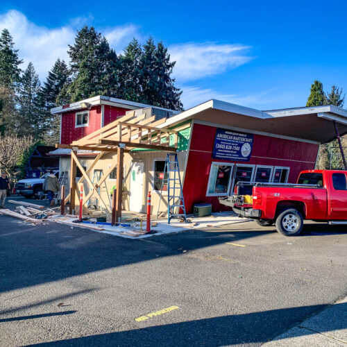 Construction siding project on a red two story building