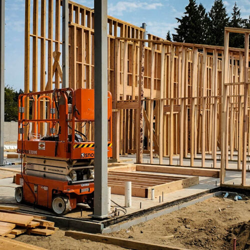 Boom lift on a new construction build site with wooden framing