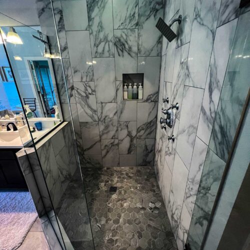 Walk-in shower with marble walls in a bathroom