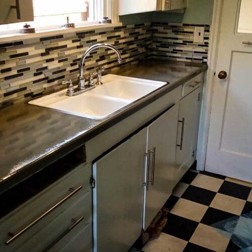 Kitchen sink area with tiled back splash