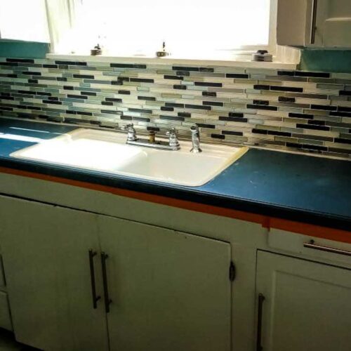 Kitchen sink area with tiled back splash