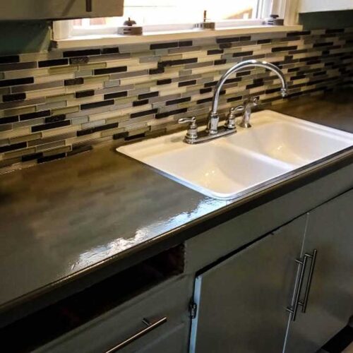 Kitchen sink area with black and white tiled back splash