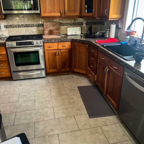 Kitchen with black granite countertops, chrome appliances and tile flooring