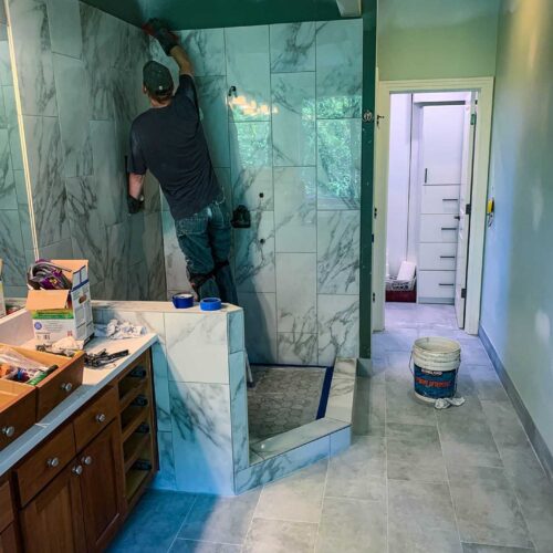 American Mastercraft worker tiling a shower