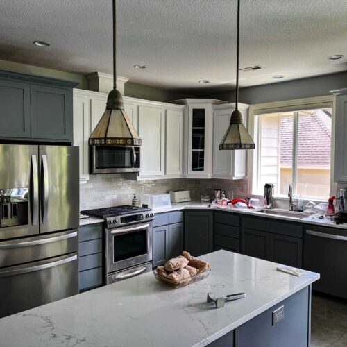 Modern kitchen with white marble counter tops and chrome appliances