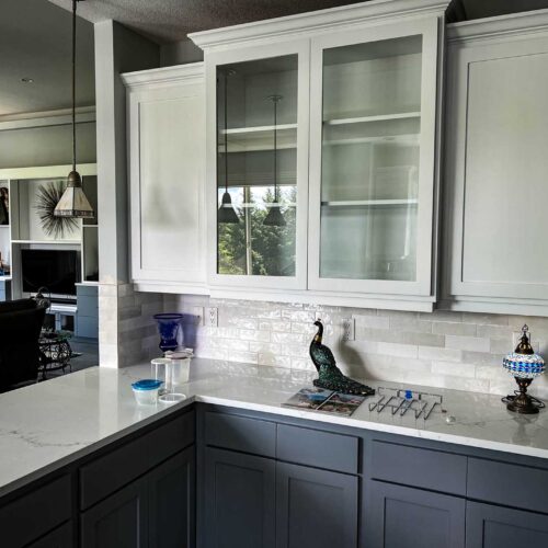 White cupboards in a modern kitchen with marble countertops