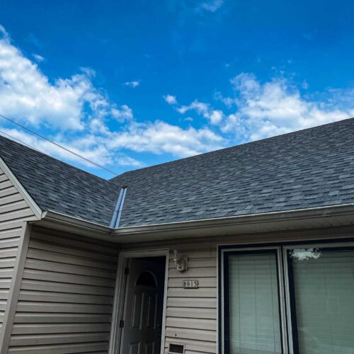 dark colored, newly replaced roof shingles over the front door way