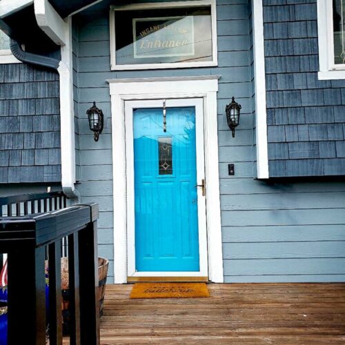 Bright blue door on a blue colored house