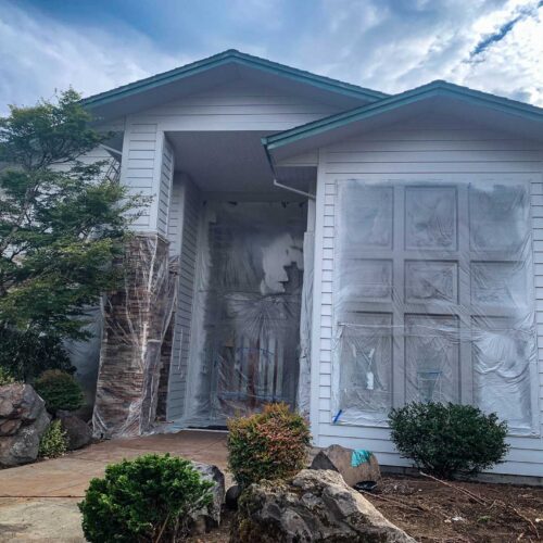 Newly painted grey colored two story home with large windows