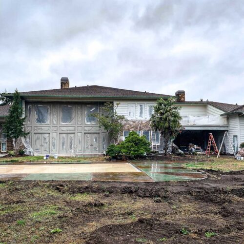 Newly painted grey colored two story home with large windows