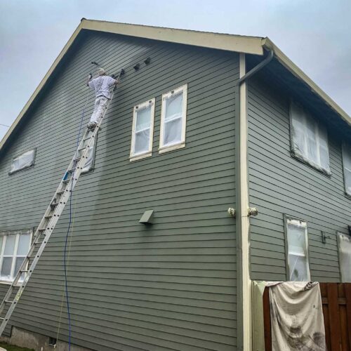 American Mastercraft painter painting the Side of a two story home