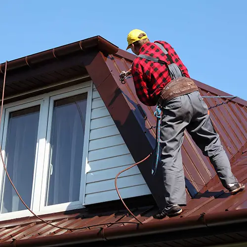 Metal roofing contractor repairing the roof on a second story home | American Mastercraft