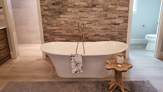 new bathroom remodel with above-floor bathtub and tiled walls, from experienced general contractors